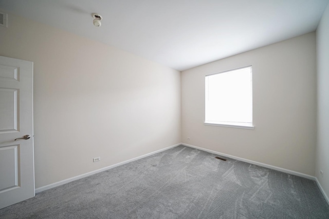 empty room featuring carpet floors, baseboards, and visible vents