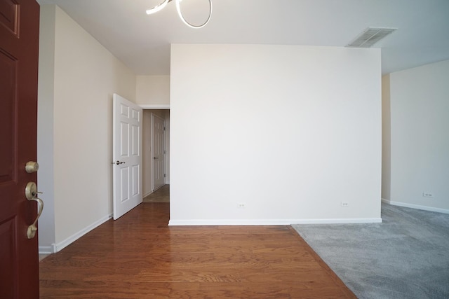 empty room with visible vents, baseboards, and wood finished floors