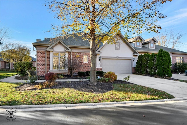 traditional home featuring a garage, concrete driveway, brick siding, and stucco siding