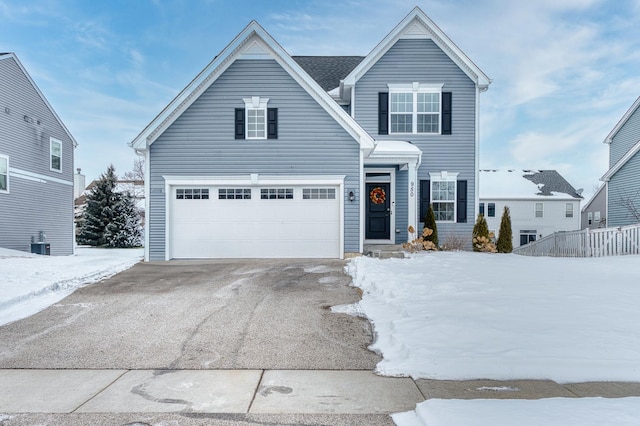 traditional-style house with a garage, central AC unit, and driveway