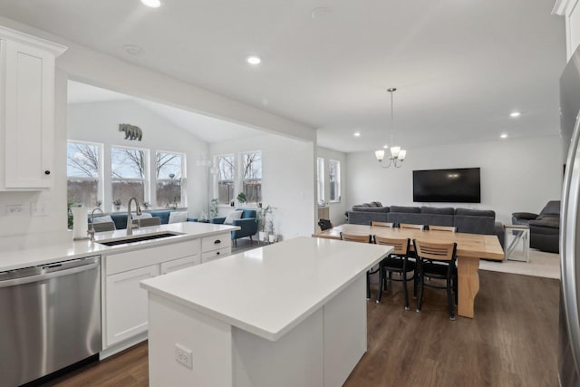 kitchen with lofted ceiling, dark wood-type flooring, a sink, open floor plan, and dishwasher