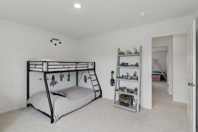 bedroom with baseboards and light colored carpet