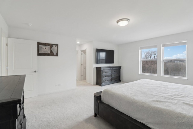 bedroom with baseboards and light colored carpet