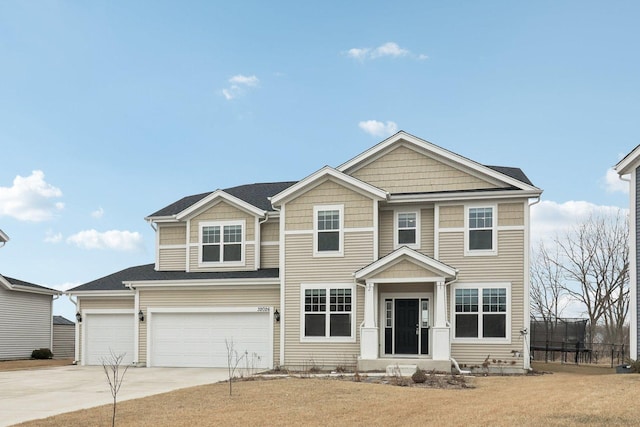 view of front of property with an attached garage, a trampoline, fence, and concrete driveway