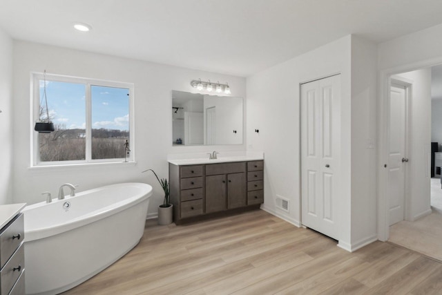 full bathroom featuring visible vents, wood finished floors, and vanity