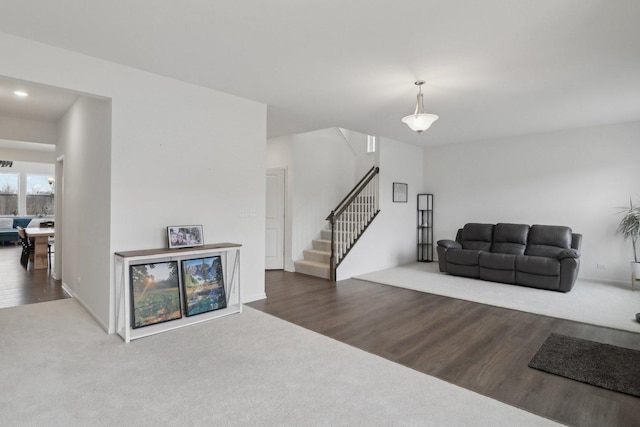 carpeted living room featuring wood finished floors and stairs