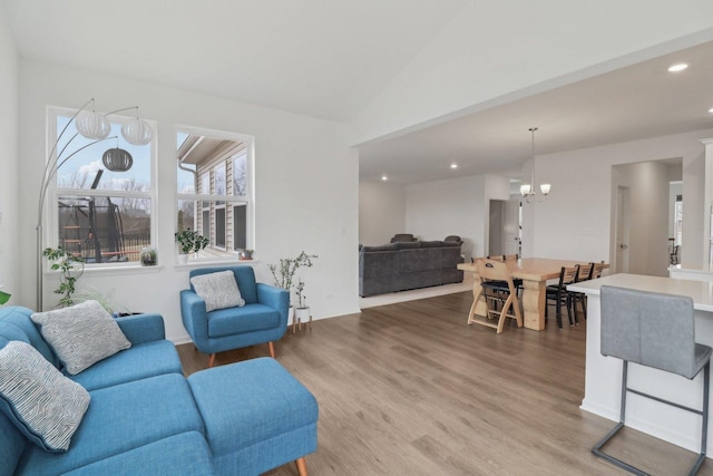 living room with lofted ceiling, a notable chandelier, recessed lighting, and wood finished floors