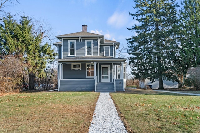 view of front of property featuring a front yard, covered porch, and a chimney