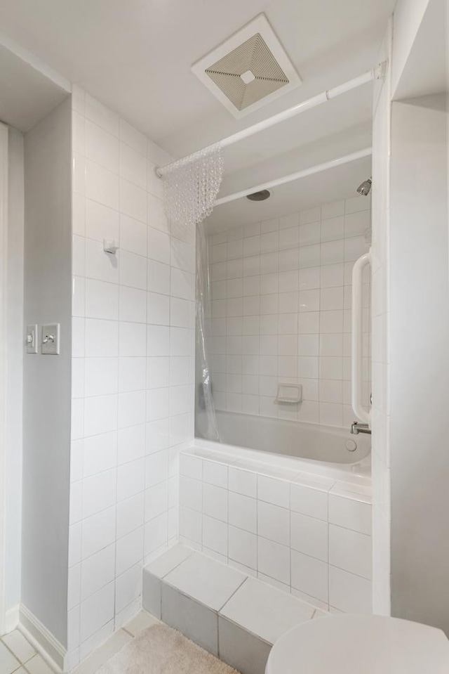 full bathroom featuring tiled shower / bath combo, visible vents, and toilet