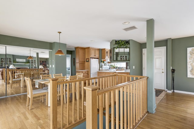 interior space featuring light wood-style flooring, visible vents, and baseboards