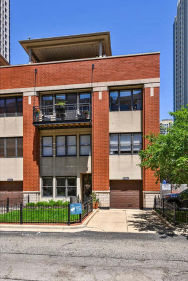 view of building exterior featuring driveway and fence