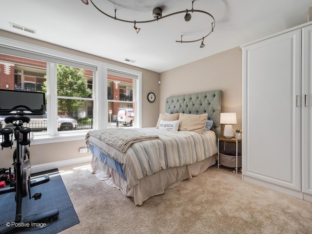 bedroom with light colored carpet, visible vents, and baseboards