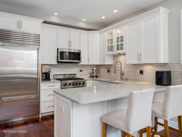 kitchen featuring light countertops, appliances with stainless steel finishes, a sink, and white cabinetry