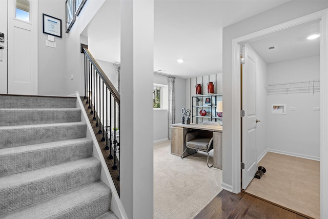 stairway with wood finished floors, visible vents, and baseboards