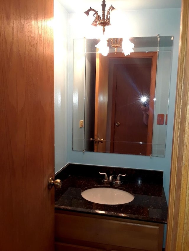 bathroom with an inviting chandelier and vanity