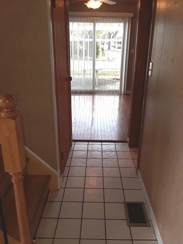 hallway featuring visible vents, baseboards, and light tile patterned floors