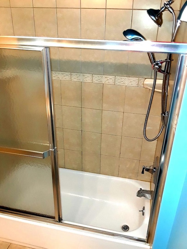 full bath featuring bath / shower combo with glass door