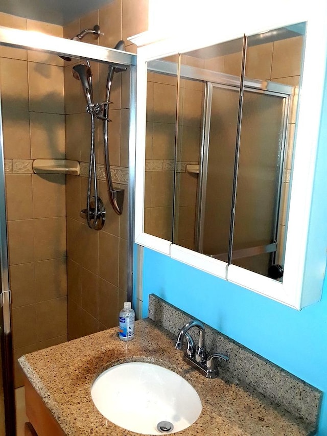 full bath with a stall shower and vanity