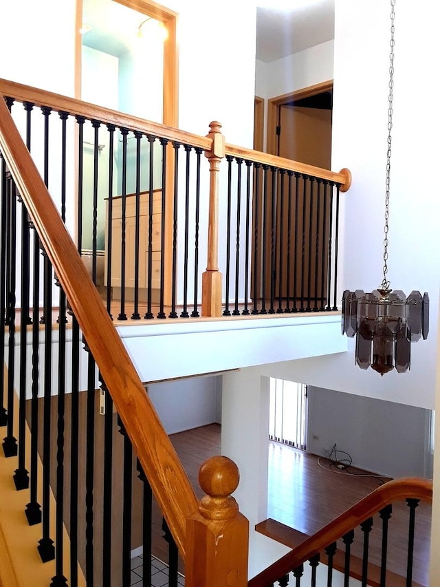 stairway with a notable chandelier