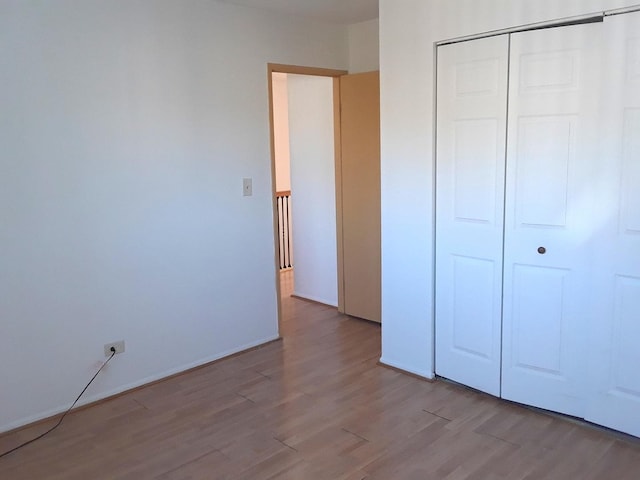 unfurnished bedroom with a closet and wood finished floors