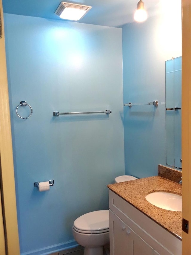 half bathroom featuring toilet and vanity