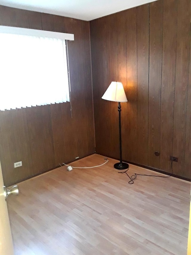 spare room with wood finished floors and wood walls