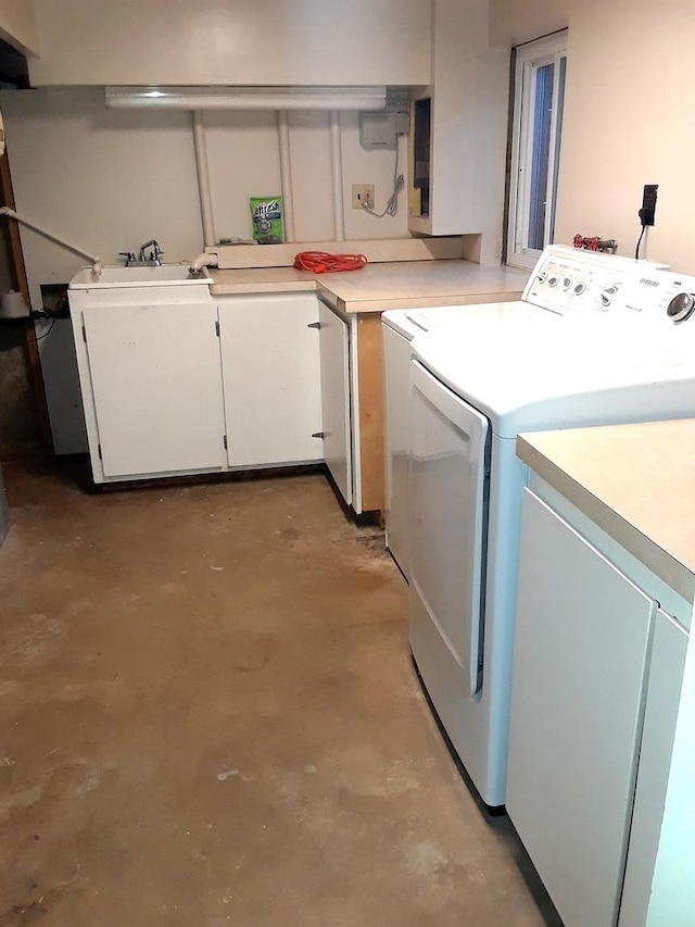 clothes washing area featuring cabinet space, washing machine and dryer, and a sink