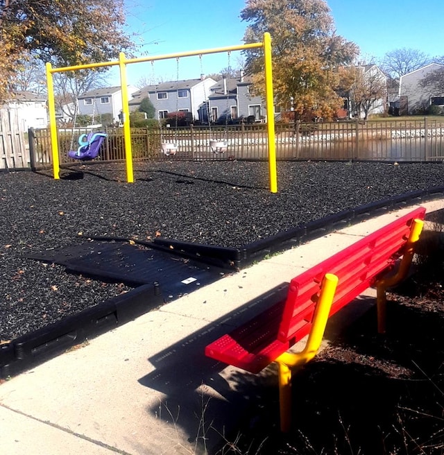 community play area with a residential view and fence