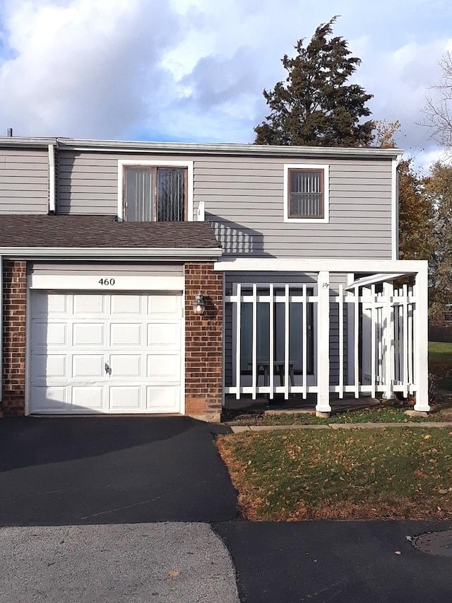 view of front of property featuring a garage, driveway, and brick siding