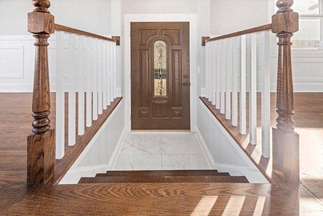 foyer entrance featuring marble finish floor and stairs