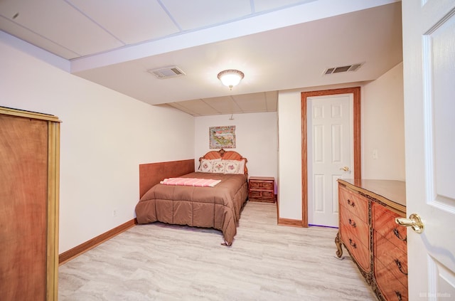 bedroom featuring light wood-style flooring, visible vents, and baseboards