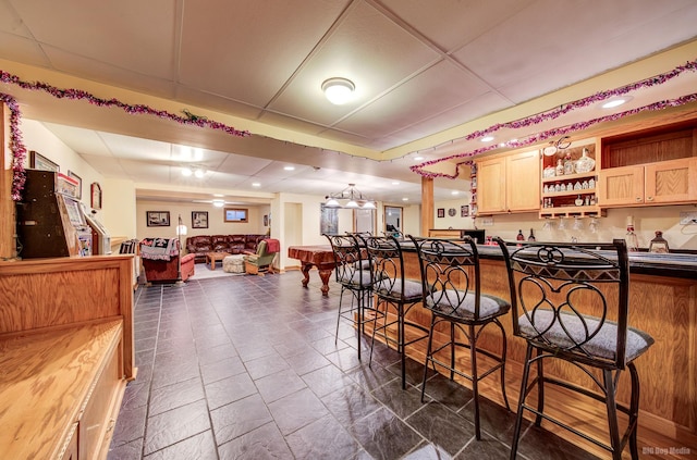 bar featuring a paneled ceiling and indoor wet bar