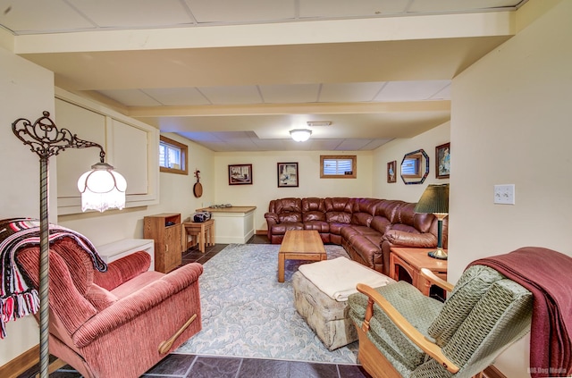 living room with a drop ceiling and baseboards