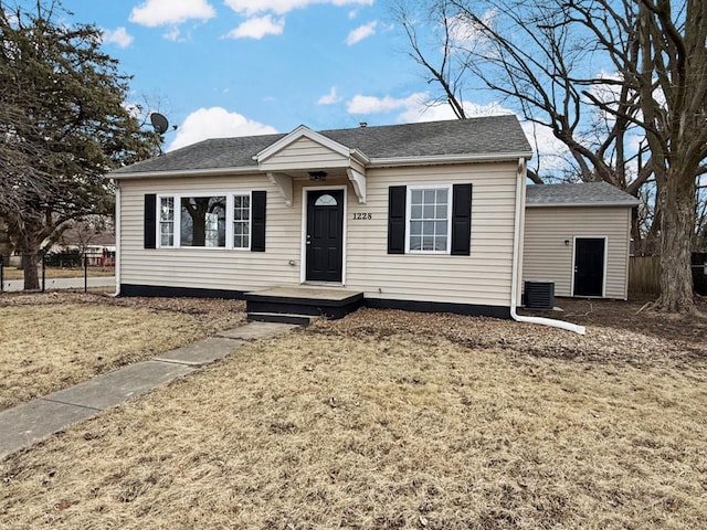 bungalow-style house with a front yard, roof with shingles, and fence