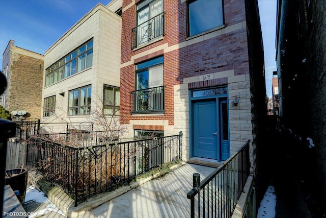 entrance to property with brick siding and fence