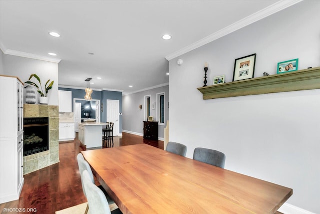 dining area featuring recessed lighting, a fireplace, baseboards, ornamental molding, and dark wood-style floors