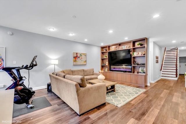 living area featuring recessed lighting, light wood finished floors, and stairs