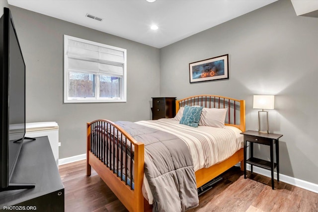 bedroom with recessed lighting, visible vents, baseboards, and wood finished floors