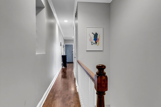 hallway featuring dark wood-style floors, baseboards, an upstairs landing, and crown molding