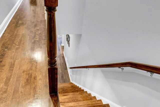 stairway with baseboards and wood finished floors