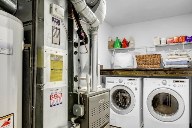 washroom with laundry area, washer and clothes dryer, and heating unit