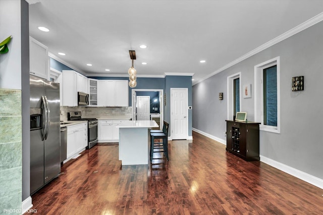 kitchen with a center island, a breakfast bar area, light countertops, decorative backsplash, and appliances with stainless steel finishes