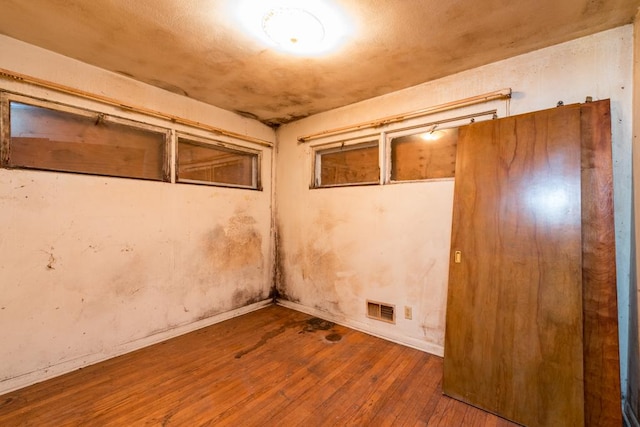 basement featuring wood-type flooring and visible vents