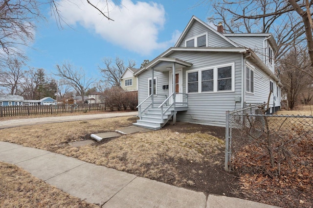 bungalow-style house with a fenced front yard and a chimney