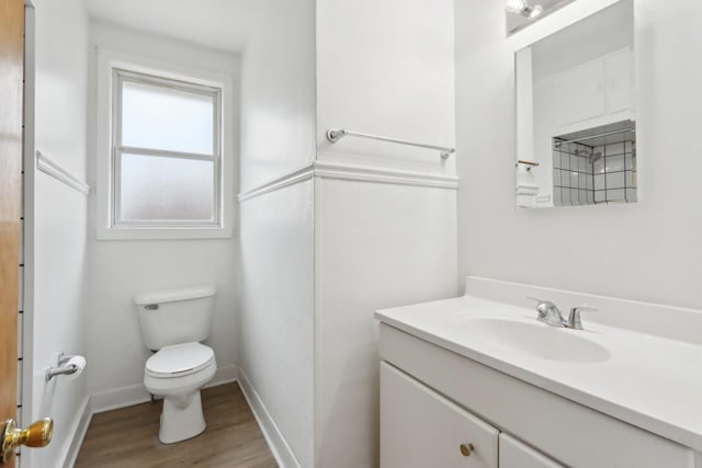 bathroom with baseboards, vanity, toilet, and wood finished floors