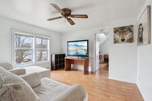 living room featuring ceiling fan, light wood-style flooring, and baseboards