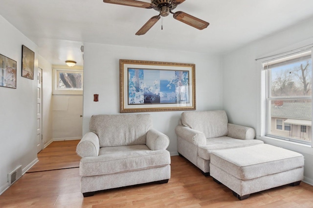 sitting room featuring visible vents, ceiling fan, light wood-style flooring, and baseboards