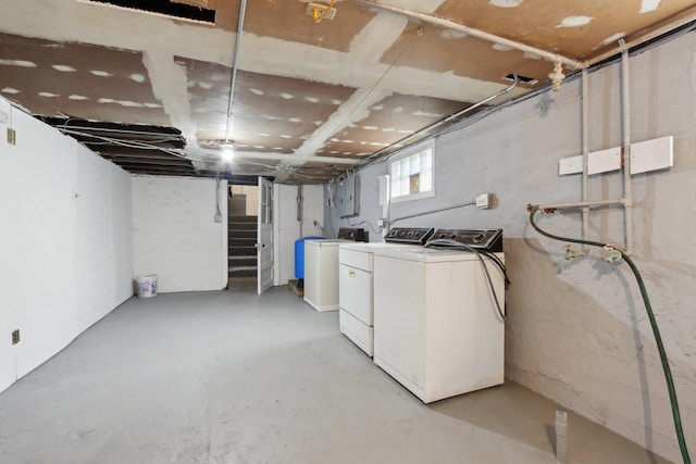 basement featuring washing machine and dryer and stairway