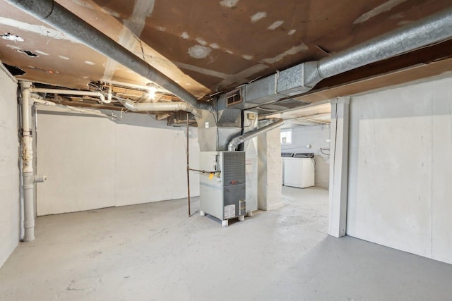 basement with washer / dryer, visible vents, and heating unit