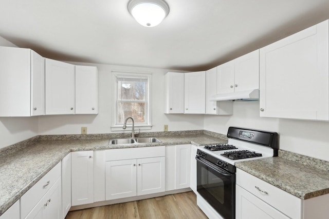 kitchen featuring range with gas stovetop, light wood-style flooring, white cabinetry, a sink, and under cabinet range hood